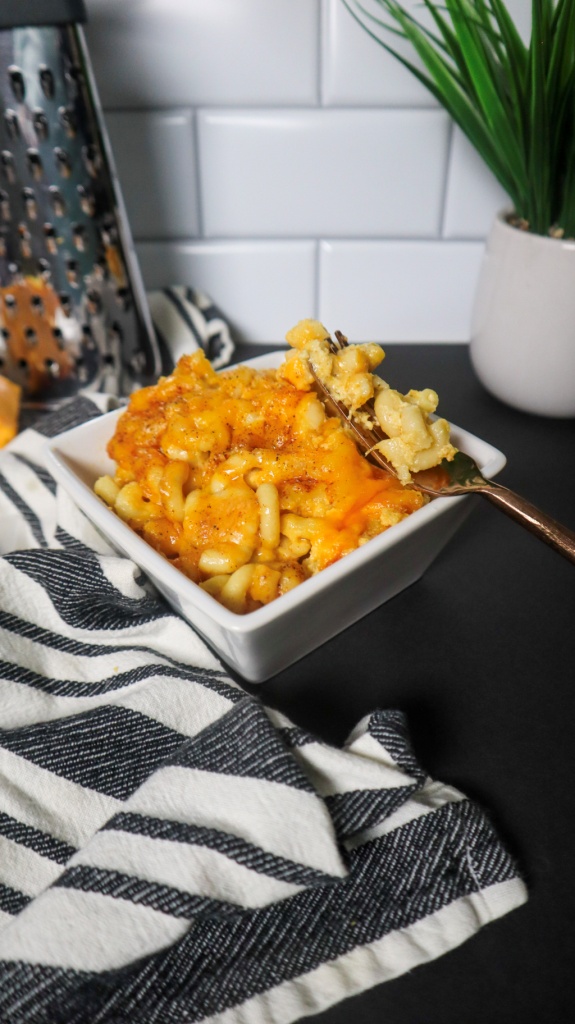 A bowl of southern baked macaroni and cheese in a white bowl and fork.